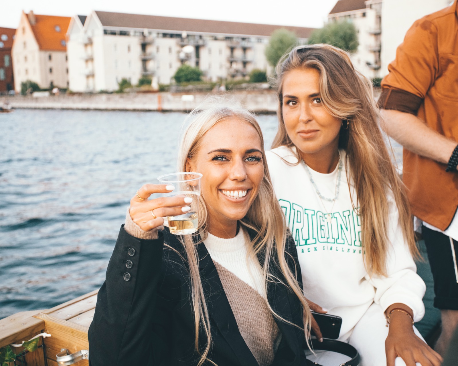 To smilende piger nyder en drink på Green Raft