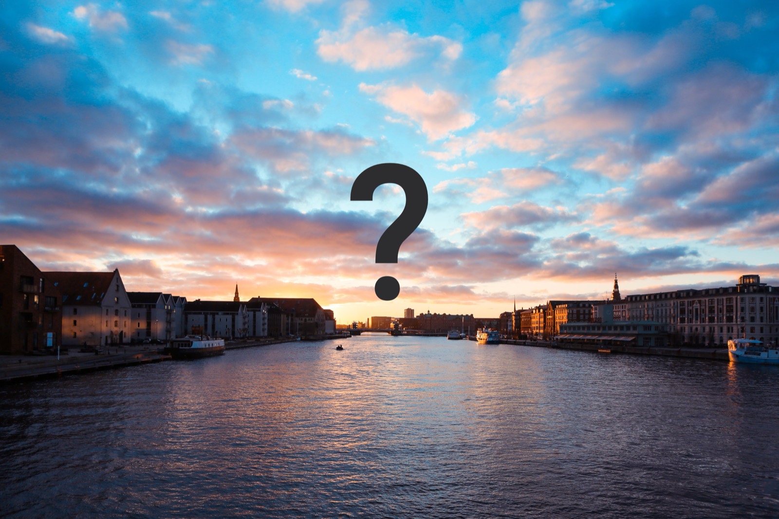 Et spørgsmålstegn over havnen i solnedgang